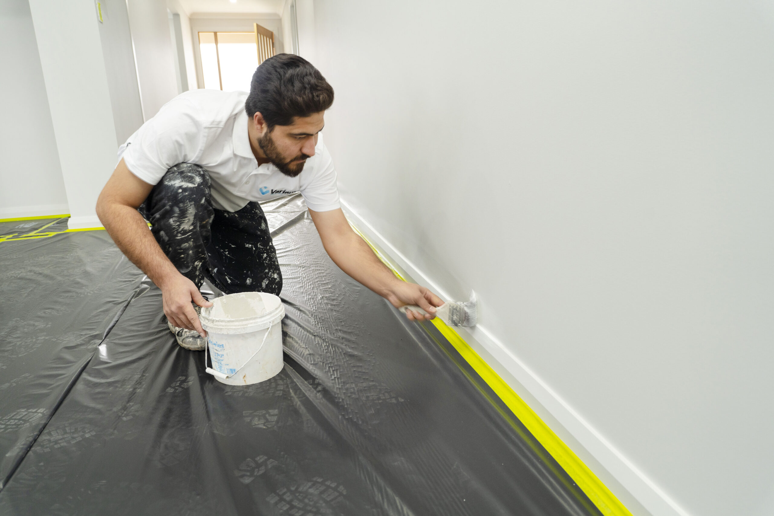 Interior house painting in progress with a professional painter applying fresh coats to a wall