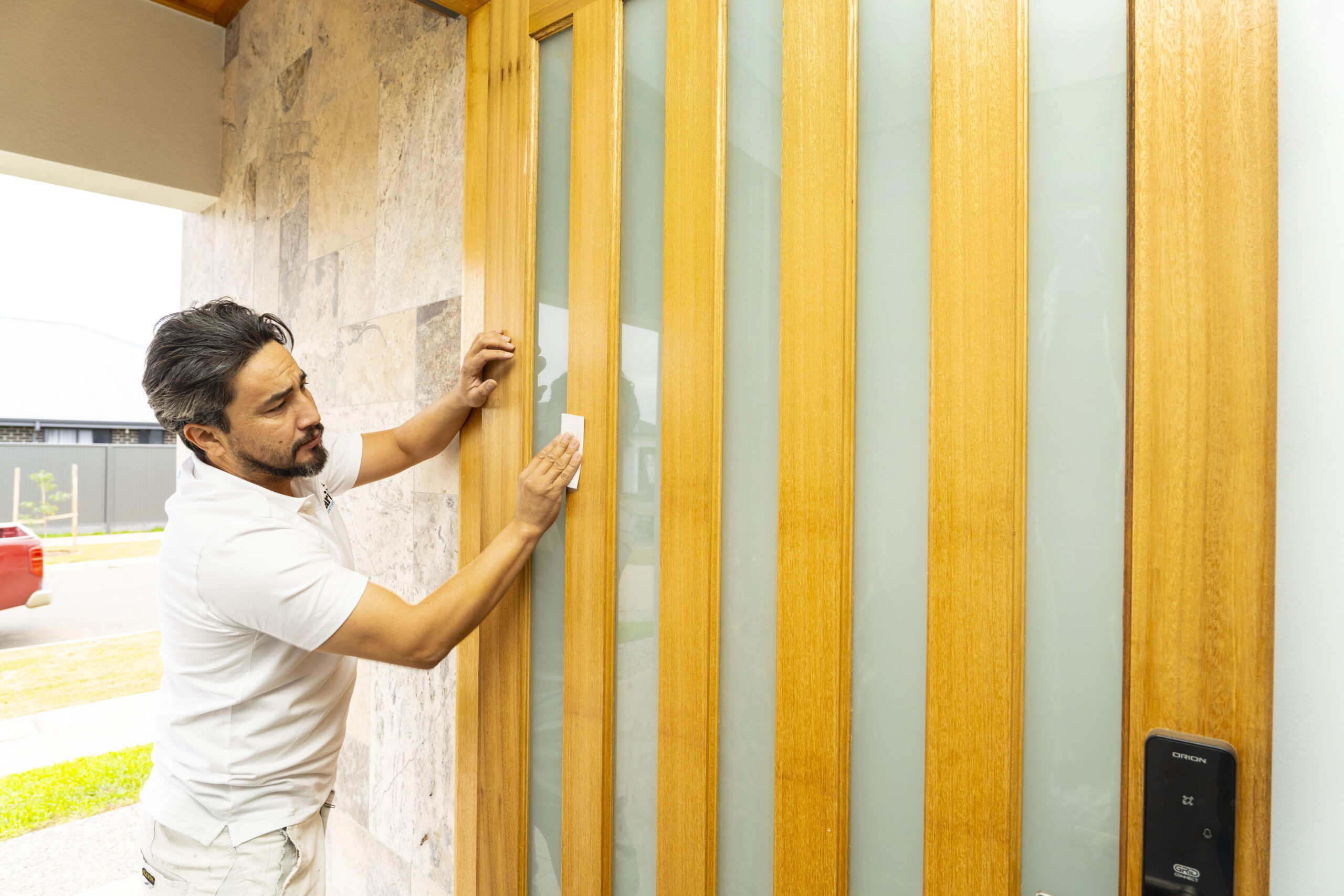 A professional painter working on the exterior of a house, showing the quality and care behind expert exterior painting in Adelaide
